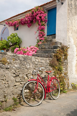 Fototapeta na wymiar Vieux vélo rouge dans les rues de Noirmoutier