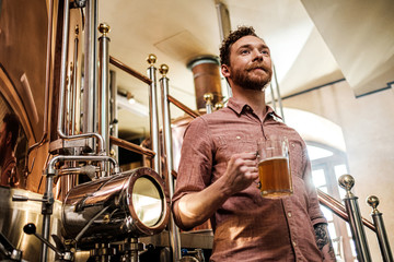 Fototapeta na wymiar Man tasting fresh beer in a brewery