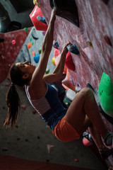 Obraz na płótnie Canvas Athletic woman practicing in a bouldering gym