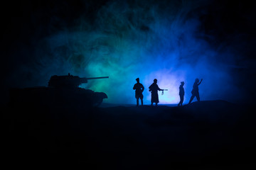 Fototapeta na wymiar Battle scene. Military silhouettes fighting scene on war fog sky background. A German soldiers raised arms to surrender. Plastic toy soldiers with guns taking prisoner the enemy soldier.