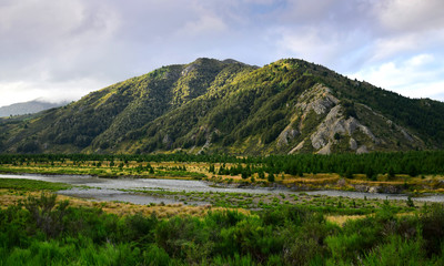 Naklejka premium Landscape in New Zealand with mountains and the Clarence river in the evening sunlight. Molesworth station, South Island.