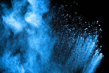 Blue powder explode cloud on black background. Launched blue dust particles splash on background.