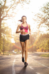 Young female in sportswear running in a park