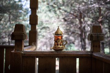 Eastern black tea in glass at the forest. Eastern tea concept. Armudu traditional cup. Green nature background.