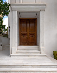 Fototapeta na wymiar contemporary elegant house entrance solid wood door and white marble walls