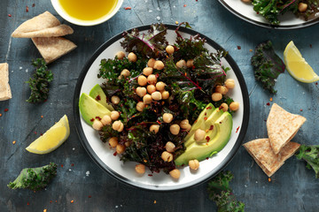 Kale Chickpeas, avocado salad with lemon on plate. healthy food.
