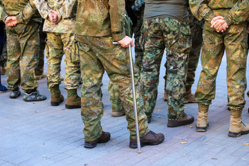 A wounded soldier of the Ukrainian army stands with a crutch near the formation of war veterans, Defender Ukraine Day. Armed forces of Ukraine, Ukrainian war
