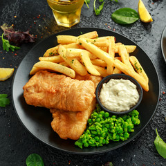 British Traditional Fish and chips with mashed peas, tartar sauce and cold beer.