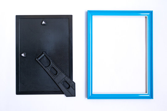 Top view of blue picture frame made wooden with inside empty space. And the back cover black with stand. Placed on white background.
