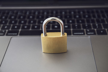 Computer security concept with a closed golden  padlock on top of the keyboard