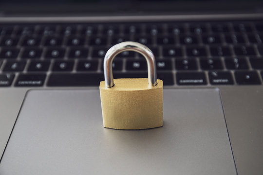 Computer security concept with a closed golden  padlock on top of the keyboard
