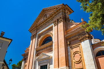 Fototapeta na wymiar The cathedral of the city of Amelia, in Umbria. The Roman-Gothic church of Sant'Agostino has a Gothic portal on the facade, with tympanum. The gable, columns with capitals and the rose window.
