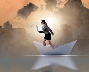 Businesswoman riding paper boat ship in business concept