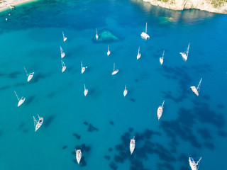 Aerial top view photo of beautiful yachts  near famous small picturesque village of Parga with turquoise crystal clear sea, Ionian, Greece
