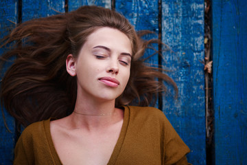 Fototapeta premium Beautiful caucasian young woman Lying on her back on wooden background.