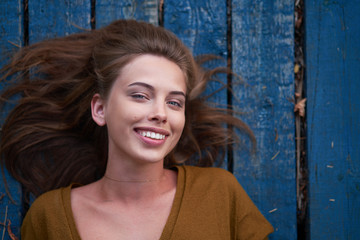 Beautiful caucasian young woman Lying on her back on wooden background.