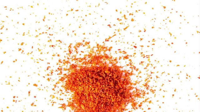 panning chilli pepper powder isolated on white background. top view
