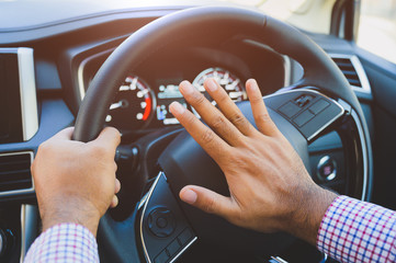 Naklejka premium Hand man pushing car horn while driving car.