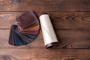 Leather samples for shoes on dark wooden table.