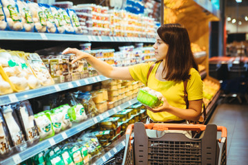 young pretty adult woman do shopping in grocery store