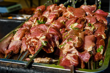 Skewers with raw meat over the charcoals. Cooking shashlik
