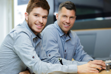 two men workers smiling at the camera