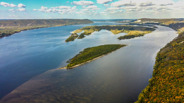 Aerial landscape view on Volga river with small sand islands and colorful green, orange and yellow forest during autumn day, Samara, Russia © VarnakovR