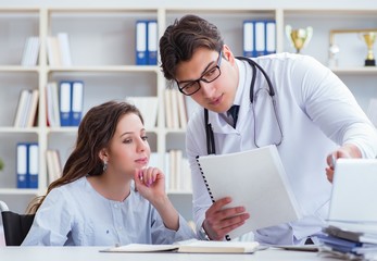 Female patient visiting male doctor for regular check-up in hosp