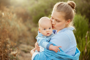 Portrait of beautiful young mother holding her baby toddler. Happy family, mother and child play concept