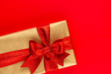 Christmas gift boxes with ribbons on red tabletop.