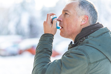 Man uses an inhaler during an asthma attack