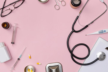 Creative flatlay of doctor medical equipment pink table with stethoscope, medical documents, thermometer, syringe and pills, Health care concept, Top view with copy space, Isolated on pink