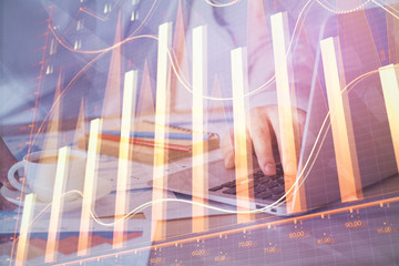 Forex graph with businessman working on computer in office on background. Concept of hardworking. Multi exposure.