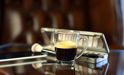 Cup of coffee with the phone and make-up set, shadow palette, and brushes
