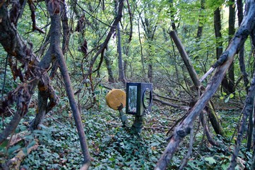 Old overgrown used railway track switch mechanism in a forest. A neglected gear shifting device, mechanism with manual control for old railway tracks. non urban solitude, merging with nature.