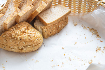 Fresh Homemade Whole Wheat Bread in wood basket on white background with copy space