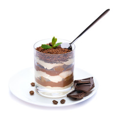 Classic tiramisu dessert in a glass cup on the plate and pieces of chocolate on white background with clipping path