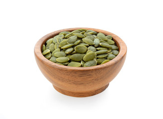 pumpkin seeds in wooden bowl isolated on white background