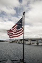 Pearl Harbor, Hawaii - August 23rd 2019: American flag flying on a cloudy day on the USS Bowfin Submarine at Pearl Harbor.