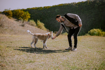 The man gives the dog a feed on at nature, husky look at food on my hand