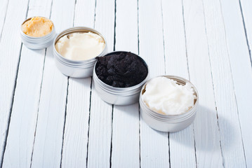 shea, macadamia nut and coffee butter, black cosmetic mud on white wooden table background