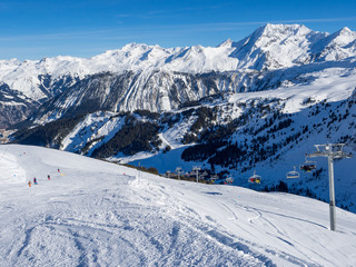 Fototapeta na wymiar France, february 2019: Skiers on a piste at Courchevel ski resort, French Alps