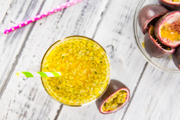 Healthy Maracuja Juice on a wooden table as detailed close-up shot (selective focus)
