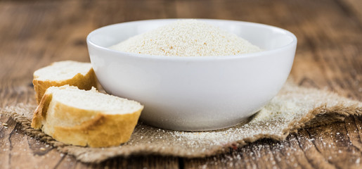 Some fresh Bread Crumbs on wooden background (selective focus; close-up shot)