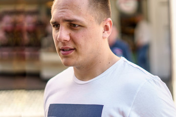 Thoughtful young man walking in an urban street