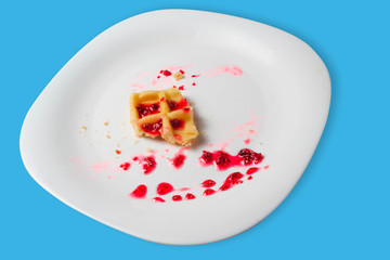 Belgian waffle with raspberry jam on a blue background. copy space