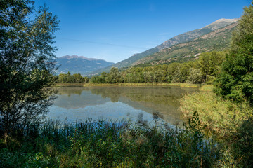 Fototapeta na wymiar mountain panorama with blue lake in the last days of summer
