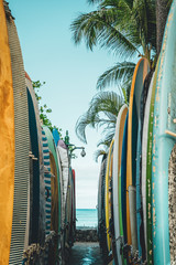 Looking through a row of surfboards down to Waikiki Beach. © Nick