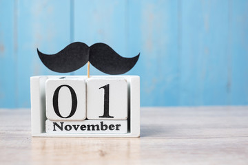 1 November Calendar and mustache on wood table background. Father, International men day, Prostate Cancer Awareness and World cancer day concept