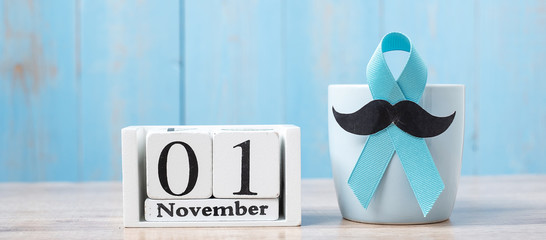 Blue coffee cup, blue ribbon, Black mustache and 1 November Calendar.  in the morning. Father, International men day, Prostate Cancer Awareness and World cancer day concept